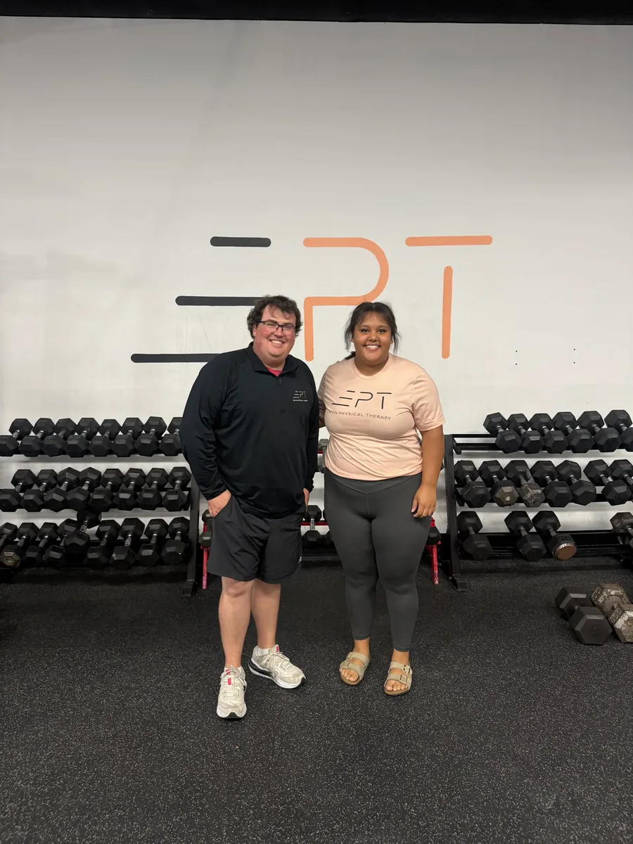 Patient and therapist standing together in the clinic gym